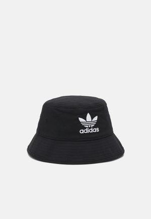 Schwarzer Bucket Hat aus Baumwolle mit einem weißen, gestickten Adidas-Logo und einem breiten, nach unten geneigten Schirm.