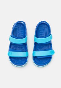 Sandalias azul con dos correas ajustables, plantilla texturizada y detalles circulares en la correa. Ligeras, fabricadas en material sintético.