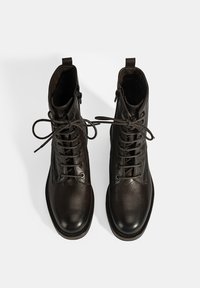 Donkerbruine leren enkellaarsjes met een ronde neus, voorzien van veters en een zijrits. Glad oppervlak met een subtiele glans en een stevige zool.