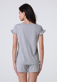 Set da notte grigio in cotone, composto da una maglietta a maniche corte con maniche volant e pois bianchi, abbinata a pantaloni corti coordinati.