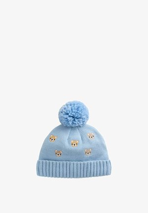 Hellblaue gestrickte Babymütze mit großem Bommel oben und kleinen, um die Krone herum bestickten Teddybärgesichtern.