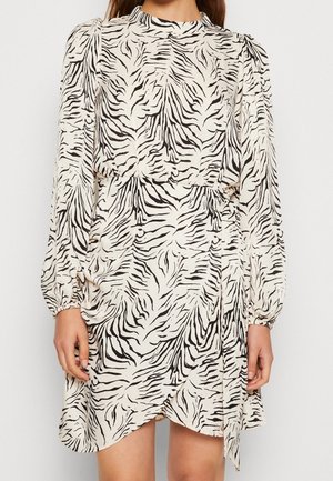 Gedrucktes Kleid mit hellbeiger Basis und schwarzen Zebrastrifen, langen Ärmeln, rundem Ausschnitt und einer Bindung in der Taille.