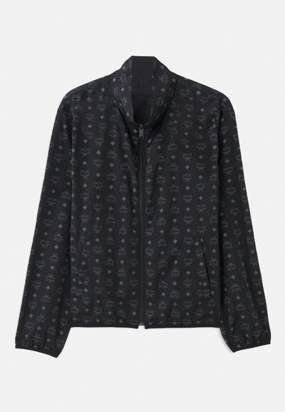 Giacca nera con un sottile motivo logo su tutta la superficie, caratterizzata da una chiusura a zip frontale, colletto alto e polsini elasticizzati per una forma aderente.