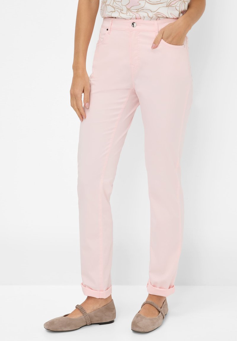 Lichtroze, slim-fit broeken met voorzakken, omslagrokken en een knoopsluiting. Draag ze met taupe flats, met een ronde neus en een bandje.
