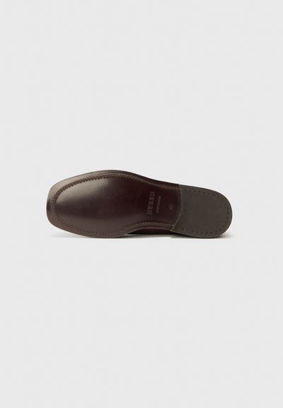Sole della scarpa in pelle di colore marrone scuro con punta arrotondata. Presenta cuciture a contrasto e una sezione in gomma grigia testurizzata nel tallone.