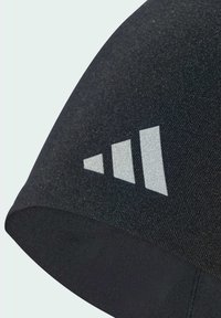 Czarna sportowa czapka o gładkiej fakturze, z logo składającym się z trzech ułożonych w stos szarych trójkątów z boku. Zaprojektowana z myślą o odzieży sportowej.