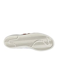 Bílá podrážka tenisky s texturovanou gumou a vzorem běhounu ve tvaru cik-cak; jemné béžové akcenty u okrajů.