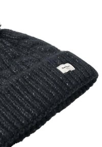 Beanie a maglia grigio scuro, con un bordo a coste e un piccolo patch con logo bianco. Texture morbida con un motivo screziato.