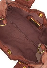 Interno di una borsa a tracolla in pelle marrone con una morbida fodera in tessuto, hardware dorato e dettagli di cucitura visibili. Presenta occhielli metallici per la chiusura.