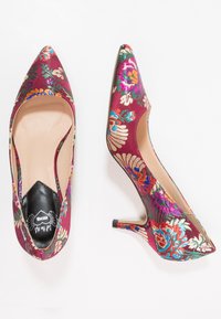 Décolleté con punta affilata, realizzate in satin bordeaux, caratterizzate da vivaci ricami floreali in vari colori. Tacco sottile e aperture laterali.