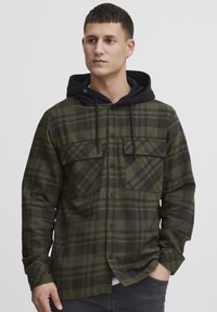 Grøn- og sortternet flannel skjorte med to brystlommer, knaplukning og en sort hætte. Blandet bomuldsmateriale, afslappet pasform.