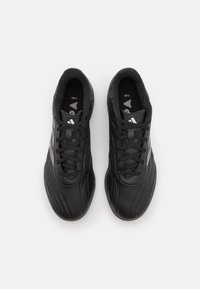 Scarpe da ginnastica nere con un design aerodinamico, caratterizzate da un materiale sintetico testurizzato, punta rotonda e accenti bianchi a contrasto con il logo.