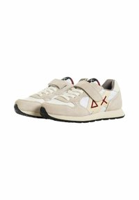 Sneaker beige e bianchi con tomaia in suede, dotate di una fascia in velcro e un accento di design geometrico rosso sul lato. Suola nera.