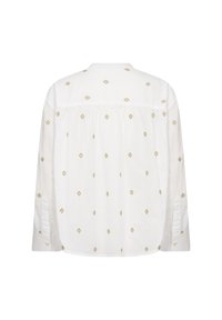 Valkoinen puuvillapaita, jossa on kultaisia timantti-embroidery, pitkät hihat, kaulus ja niskassa kerrostettua yksityiskohtaa.