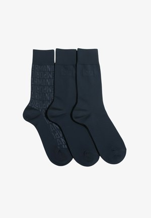 Trzy pary granatowych skarpetek z teksturowanym wzorem na jednej parze, z logo "Armani". Wykonane z miękkiego, elastycznego materiału z ściągaczami.