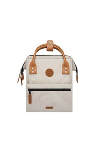 Beige fabric bag with tan leather accents, dual handles, front zip pocket, and circular logo patch. Structured design with a smooth texture.