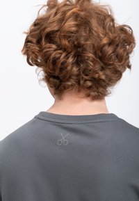 Grijze t-shirt met een ronde halslijn en korte mouwen, voorzien van een subtiele schaarafbeelding op de bovenrug. Zachte, gestructureerde stof.