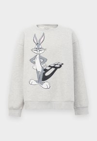 Harmaa puuvillapaita, jossa on kirjailtu Bugs Bunny -kuvio etupuolella, ja hahmon alla on varjotieto.