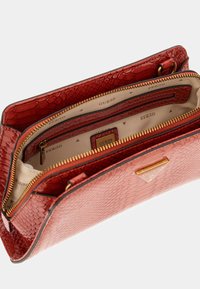 Borsa a tracolla in ecopelle di serpente rossa con rifiniture dorate, due scomparti con zip e un interno in tessuto con un delicato motivo a logo.