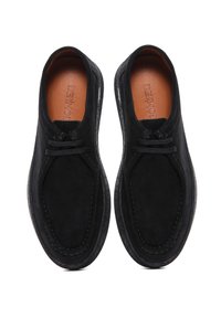 Zapatos de ante negros con una forma redondeada, cordones en la parte frontal y suela texturizada en contraste. El interior cuenta con un forro de cuero marrón.