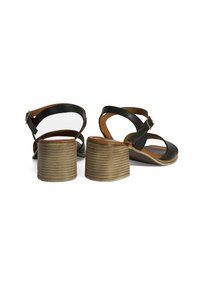 Schwarze Ledersandalen mit abgerundeten Zehen und verstellbaren Knöchellaschen. Sie verfügen über einen dicken, gerippten beigen Absatz. Holzähnlicher Fußbereich mit glatter Textur.