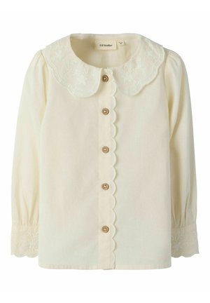 Blouse crème à manches longues avec patte de boutonnage festonnée, col rond brodé et poignets brodés.