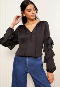 Must have, pika, pikita blouse V-kaelusega ja volangvarrukkidega. Sile kangas kerge sädelusega, kaeluse juures nööbiga kaunistused.