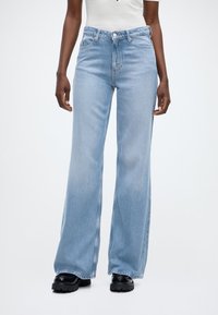 Φαρδιά τζιν παντελόνια σε ανοιχτό γαλάζιο απόχρωση με ψηλή μέση, διαθέτουν κλείσιμο με κουμπί, εμπρόσθιες τσέπες και απαλό υφή τζιν.