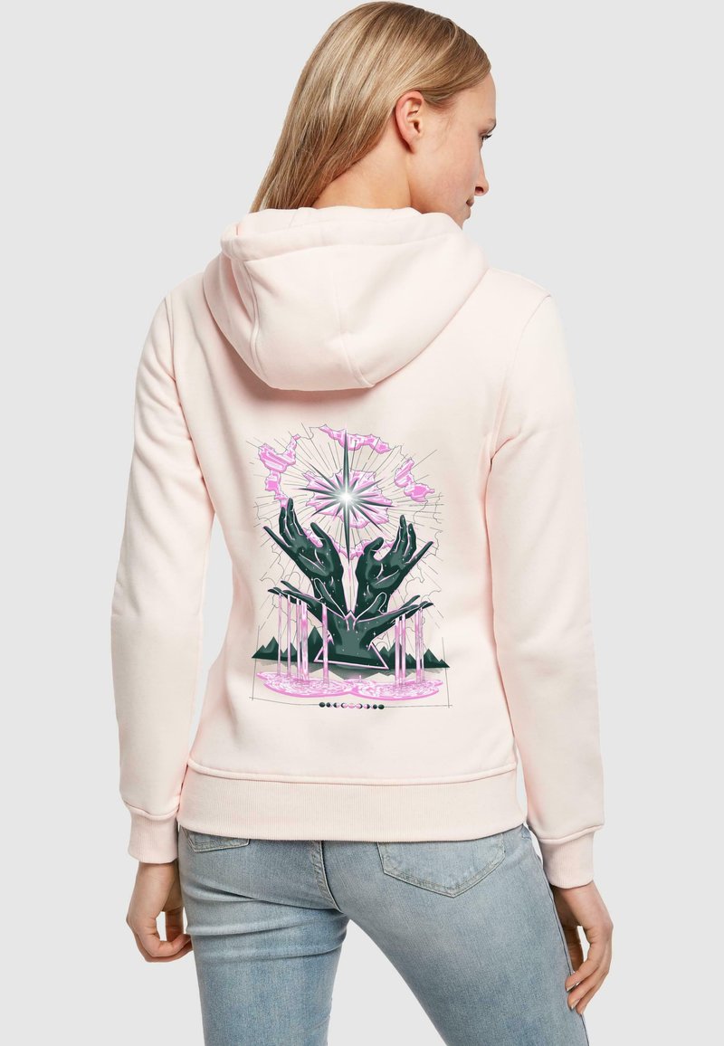 Felpa rosa chiaro con cappuccio regolabile, caratterizzata da una grafica di mani ed elementi geometrici in verde scuro e rosa sul retro.