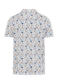 Polo blanc à manches courtes avec un petit motif floral bleu et marron, vu de dos.