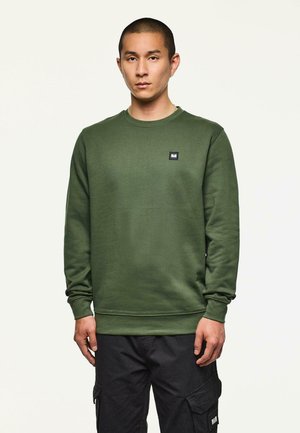 Grüner Sweatshirt mit Rundhalsausschnitt und gerippten Bündchen, versehen mit einem kleinen schwarzen Logopatch auf der Brust. Strukturierter Stoff, reguläre Passform.