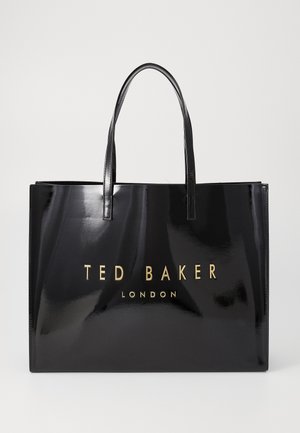 Saco tote preto brilhante com alças duplas e lettering dourado "TED BAKER LONDON" na frente. Forma retangular, textura suave.