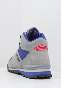 Botte de randonnée en daim gris avec accents en tissu bleu et détail de talon rose. Dotée d'un col rembourré et d'une semelle en caoutchouc pour la traction.