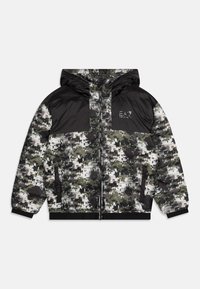 Padded Jacke mit einem Tarnmuster in Grün, Schwarz und Weiß. Verfügt über einen schwarzen oberen Bereich, eine Kapuze sowie elastische Bündchen und Saum.