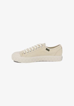 Beige canvas sneakers with a rubber toe cap, white laces, and a textured rubber sole featuring a diamond pattern. Brand label on the side.
