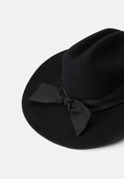 Cappello di feltro nero con una larga falda e un nastro nero legato a farfalla attorno alla base. Texture morbida con una corona strutturata.