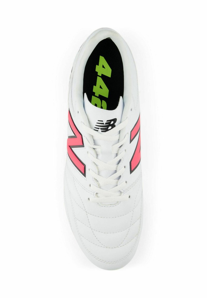Zapatilla deportiva blanca con detalles en rosa y negro, parte superior texturizada, cordones y una plantilla negra acolchada con texto verde.