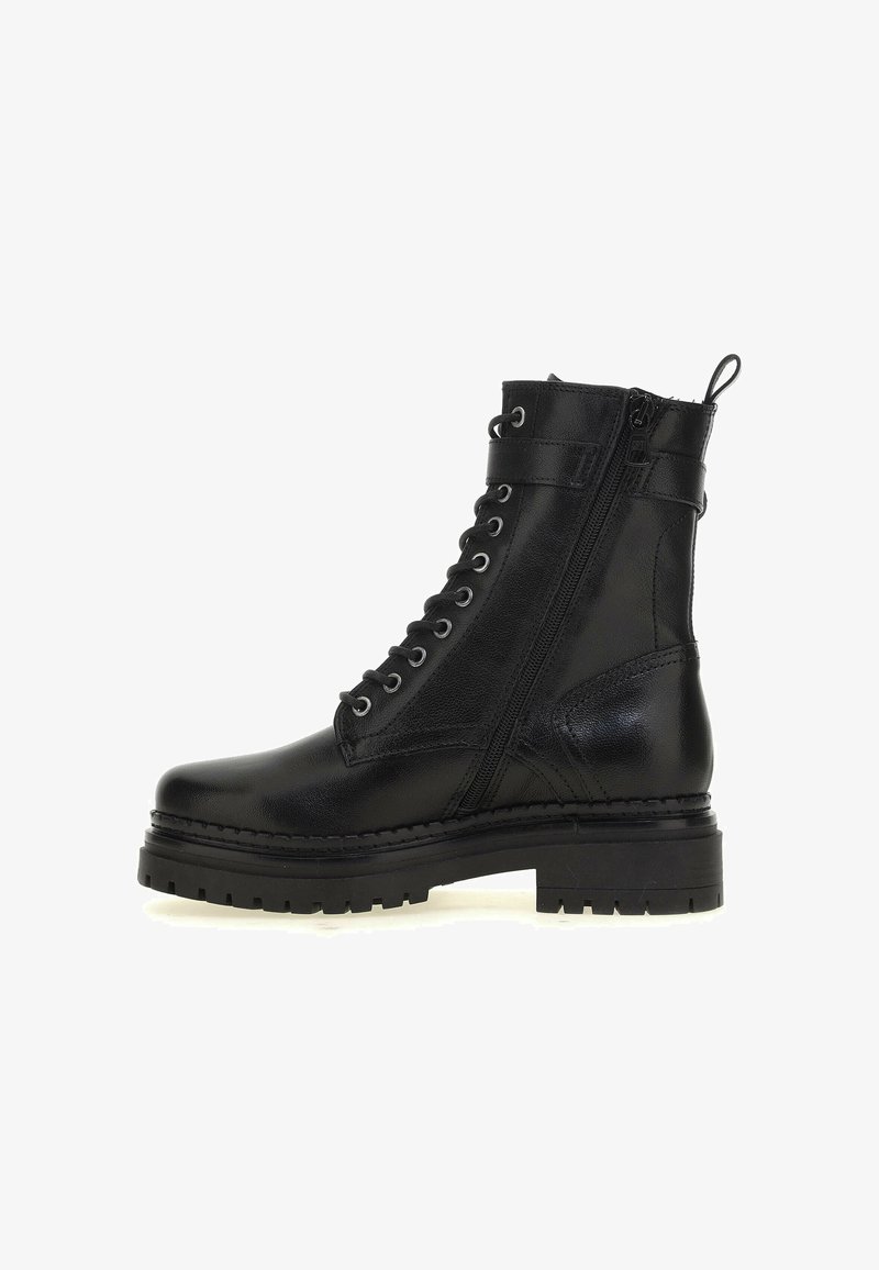 Botte de combat en cuir noir avec semelle crantée épaisse, fermeture éclair latérale, laçage à l'avant, bride à la cheville et languette de tirage à l'arrière.