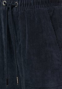 Marineblauwe corduroy shorts met een elastische tailleband, voorzien van een trekkoord, zijzakken en gestructureerde verticale ribbels.