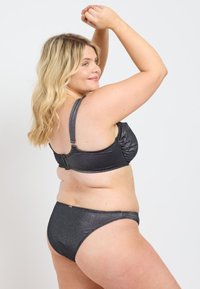 Svart metallisk bikiniuppsättning med rynkad bystdesign och justerbara axelband. Materialet verkar slätt med en blank yta.