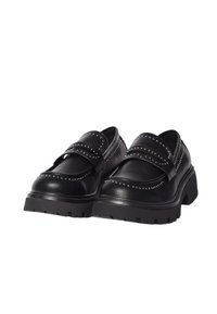 Scarpe nere in pelle con suola bassa e chunky, caratterizzate da dettagli borchiati e due cinturini sul collo del piede per una calzata sicura.