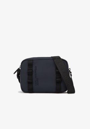 Sac bandoulière rectangulaire noir avec sangle réglable, portant la marque "Karl Lagerfeld Jeans" en lettres foncées à l'avant.