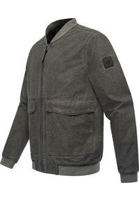 Tamno siva bomber jakna od laganog materijala. Ima zatvaranje na patentni zatvarač, rebrasti ovratnik, dva prednja džepa i zakrpu na rukavu.