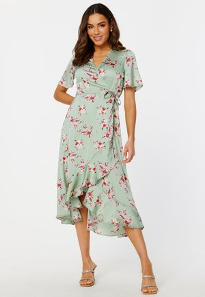 Bloemen wikkeljurk in lichtgroen met een rok met kant. Heeft korte mouwen en een strikceintuur rond de taille. Bloemenpatroon in roze en rode tinten.