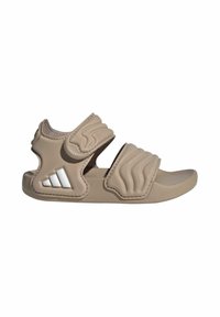 Sandalia beige con puntera abierta, dos tiras acolchadas ajustables y un logo blanco de tres franjas en el lateral del talón.