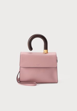 Bolso de mano rosa claro con un asa curva de madera oscura y una correa rosa a juego, colocado contra un fondo claro y liso.