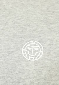 Wit gestileerd geometrisch gezicht logo gecentreerd op een lichtgrijze textured stofachtergrond.