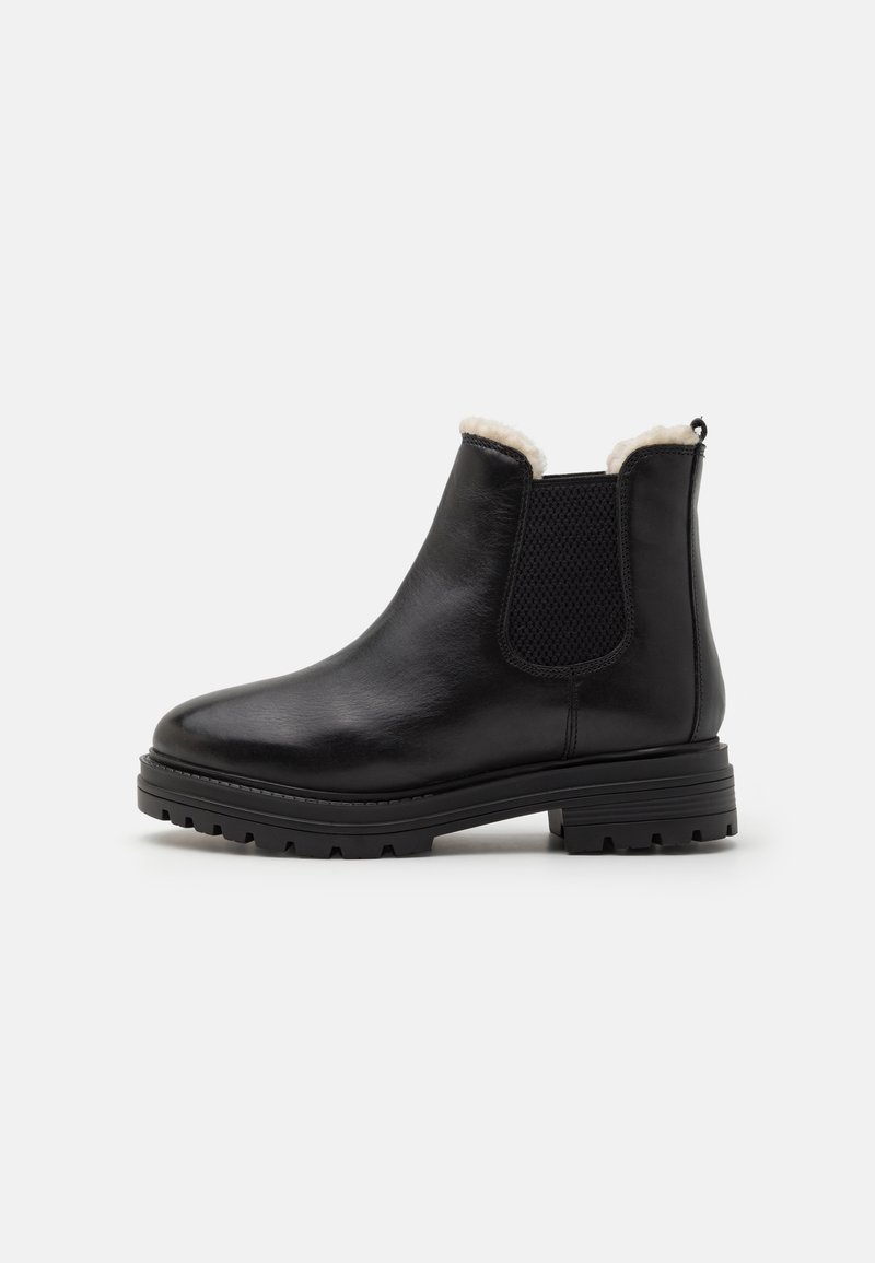Bottines en cuir noir avec un panneau latéral élastique texturé, une doublure en fausse fourrure et une semelle robuste pour une bonne traction. Design classique Chelsea.