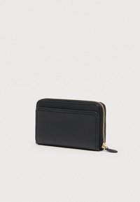 Portofel negru din piele cu fermoar pe margine, cu fanta pentru card în față și fermoar auriu, pe un fundal simplu și deschis la culoare.
