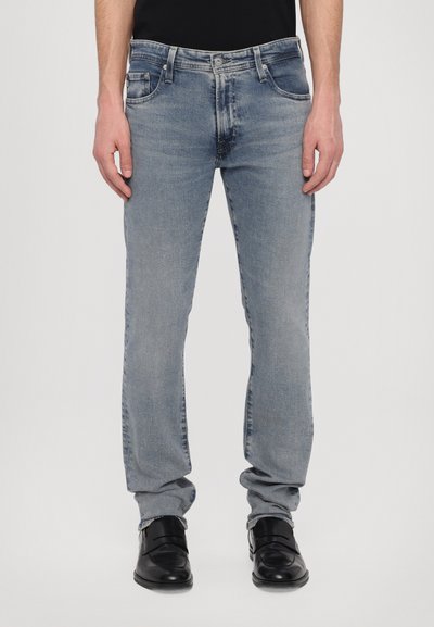 Jeans in denim azzurro chiaro con taglio dritto, cinque tasche e lavaggio medio. Presentano una chiusura con bottone e zip, con un leggero effetto sbiadito.